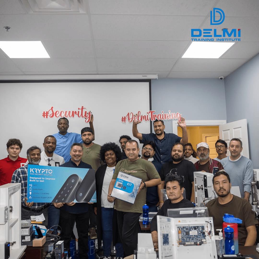Delmi Training Institute students and instructors gathered around security equipment in the classroom